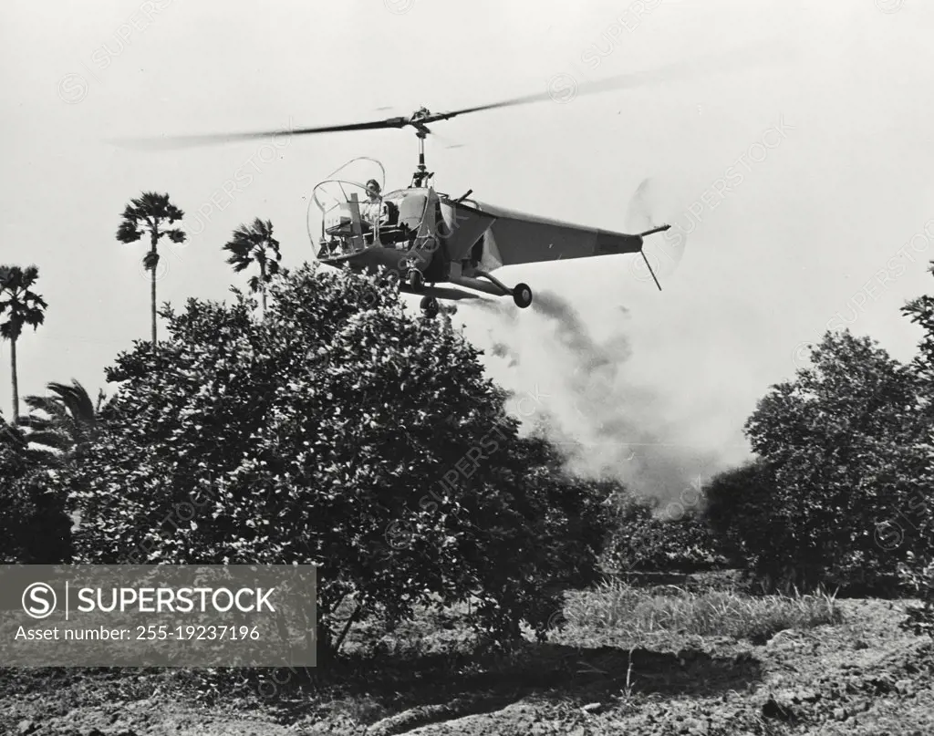Vintage photograph. Bell helicopter performing Black fly fogging operations