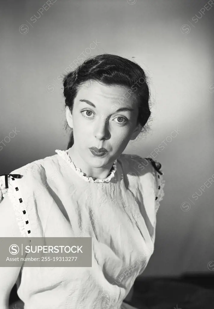 Vintage photograph. Portrait of brunette woman with pursed lips