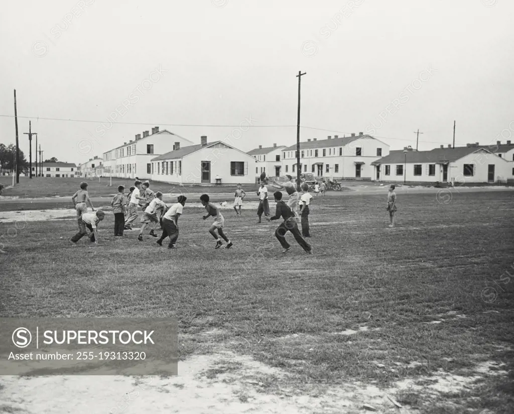 Vintage photograph. Children playing football at Newton D Baker Village Public Housing in Columbus, California