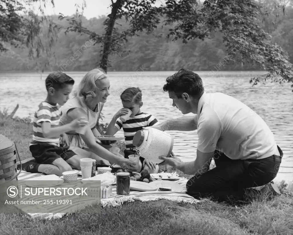 Family with two sons having picnic at lakeshore