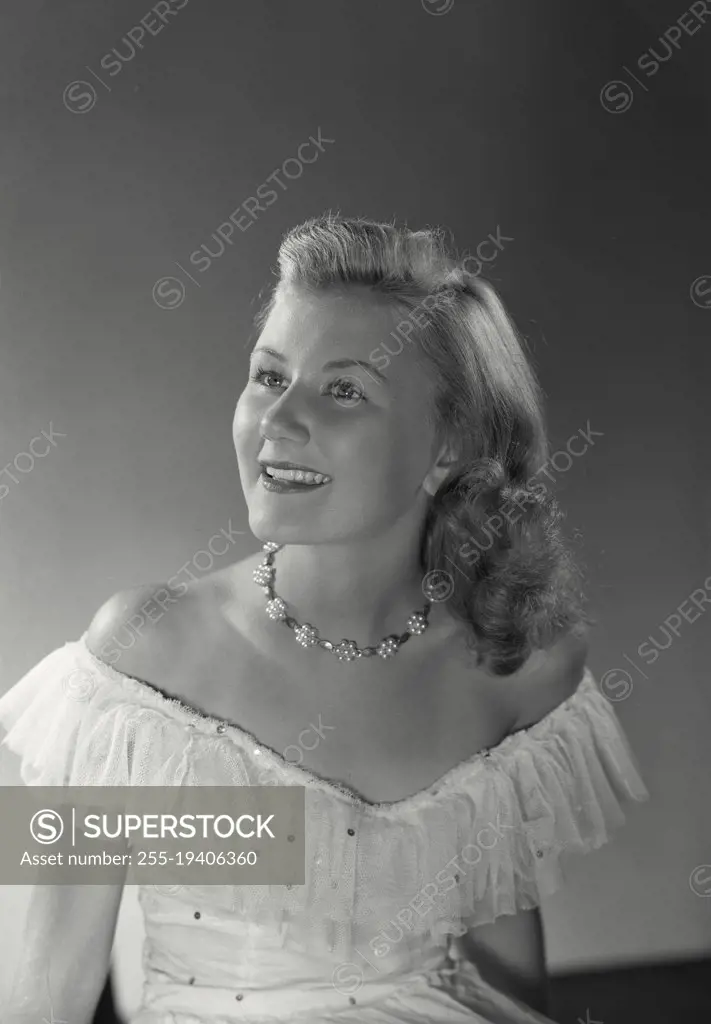 Vintage photograph. Woman in dress smiling at camera.