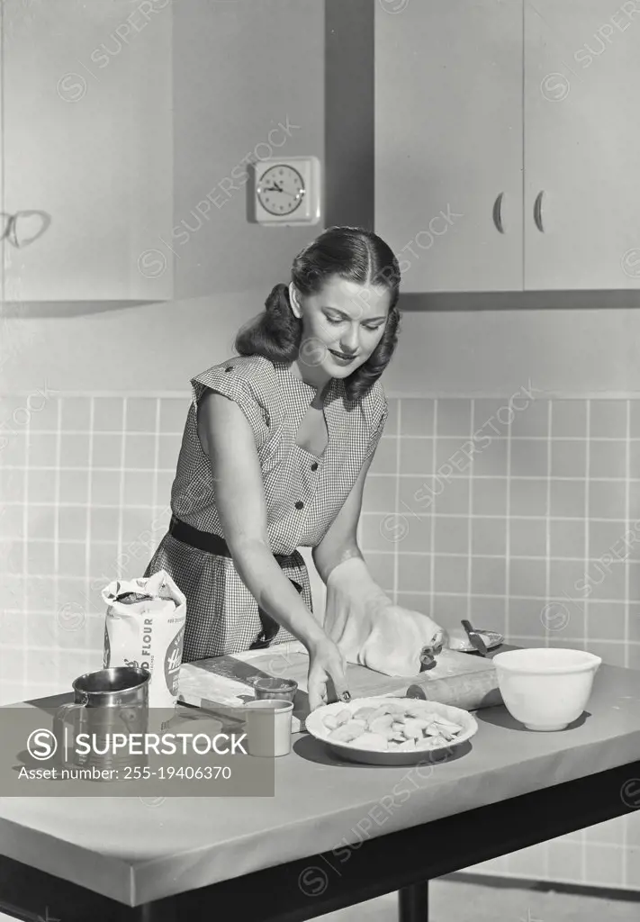 Vintage photograph. Woman rolling dough.