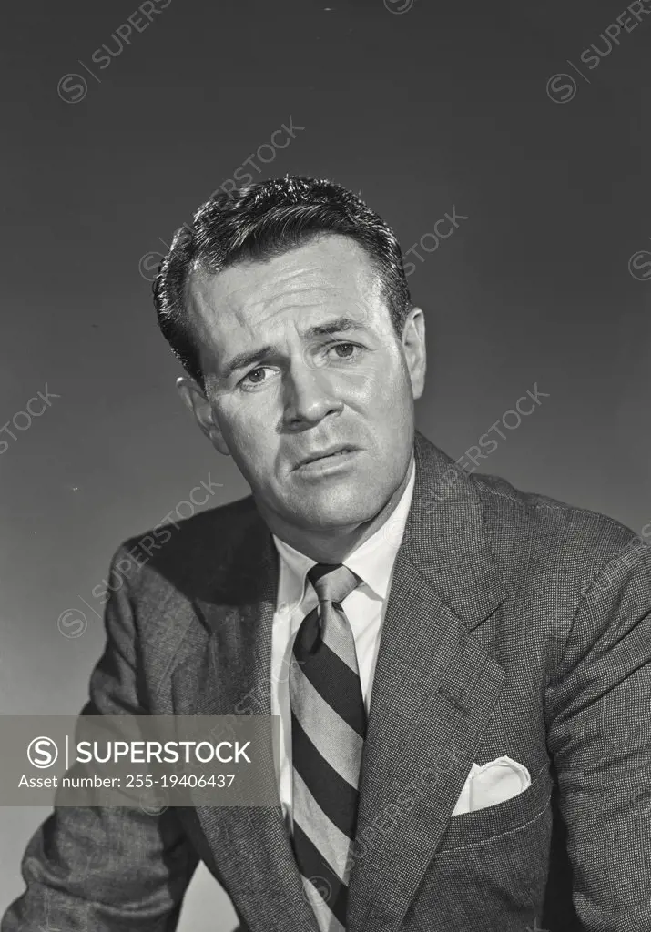 Vintage photograph. Man in suit and tie looking at camera with concerned expression