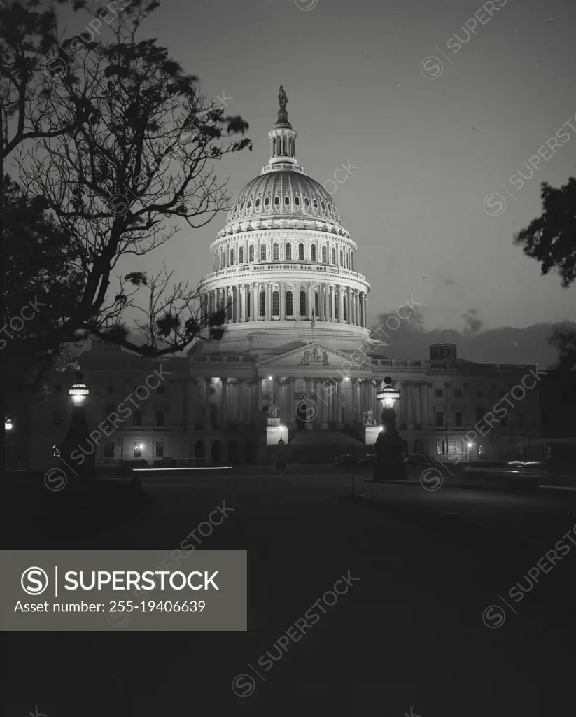 Vintage photograph. Capitol Building seen through trees at night