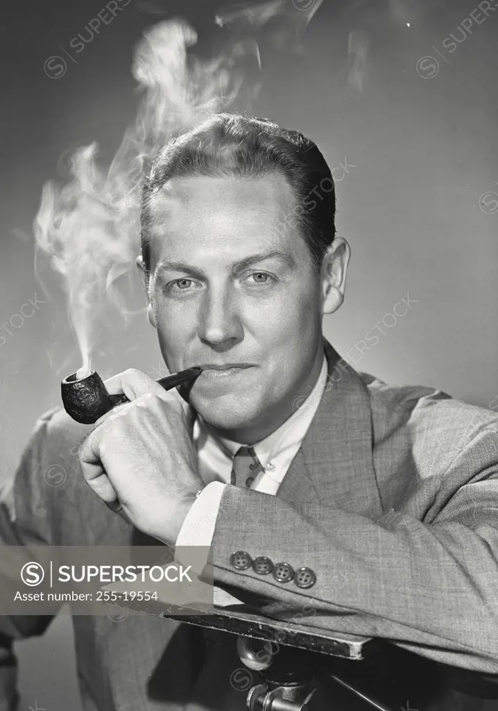 Vintage photograph. Man smoking pipe with arm on support