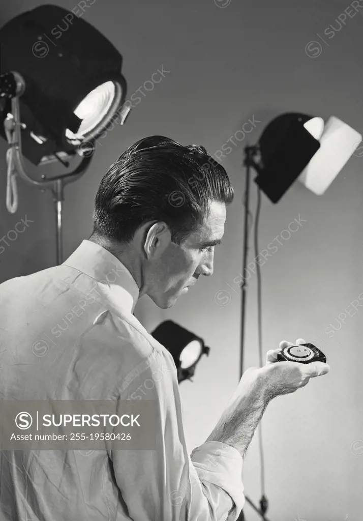 Vintage photograph. Man checking exposure meter.