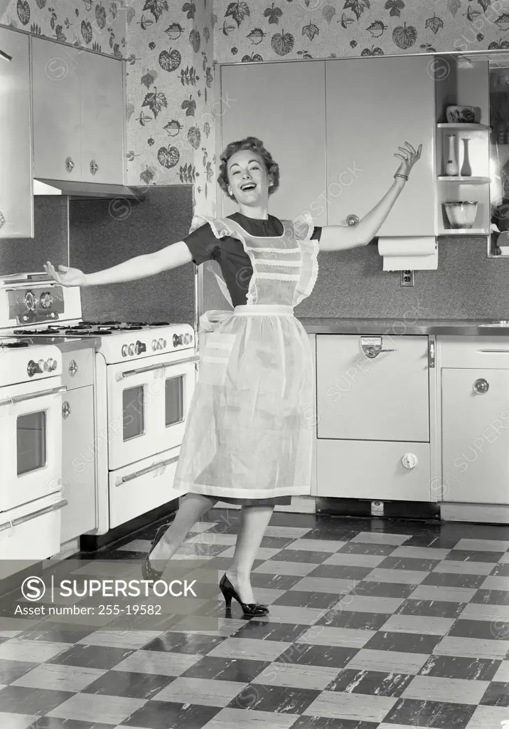 Vintage Photograph. Woman wearing apron standing in kitchen. Frame 2