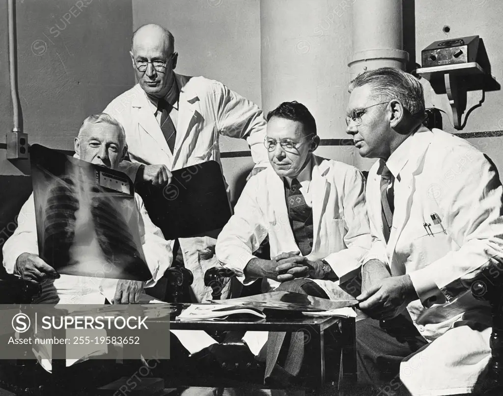 Vintage photograph. Four doctors examining an X-Ray of a chest