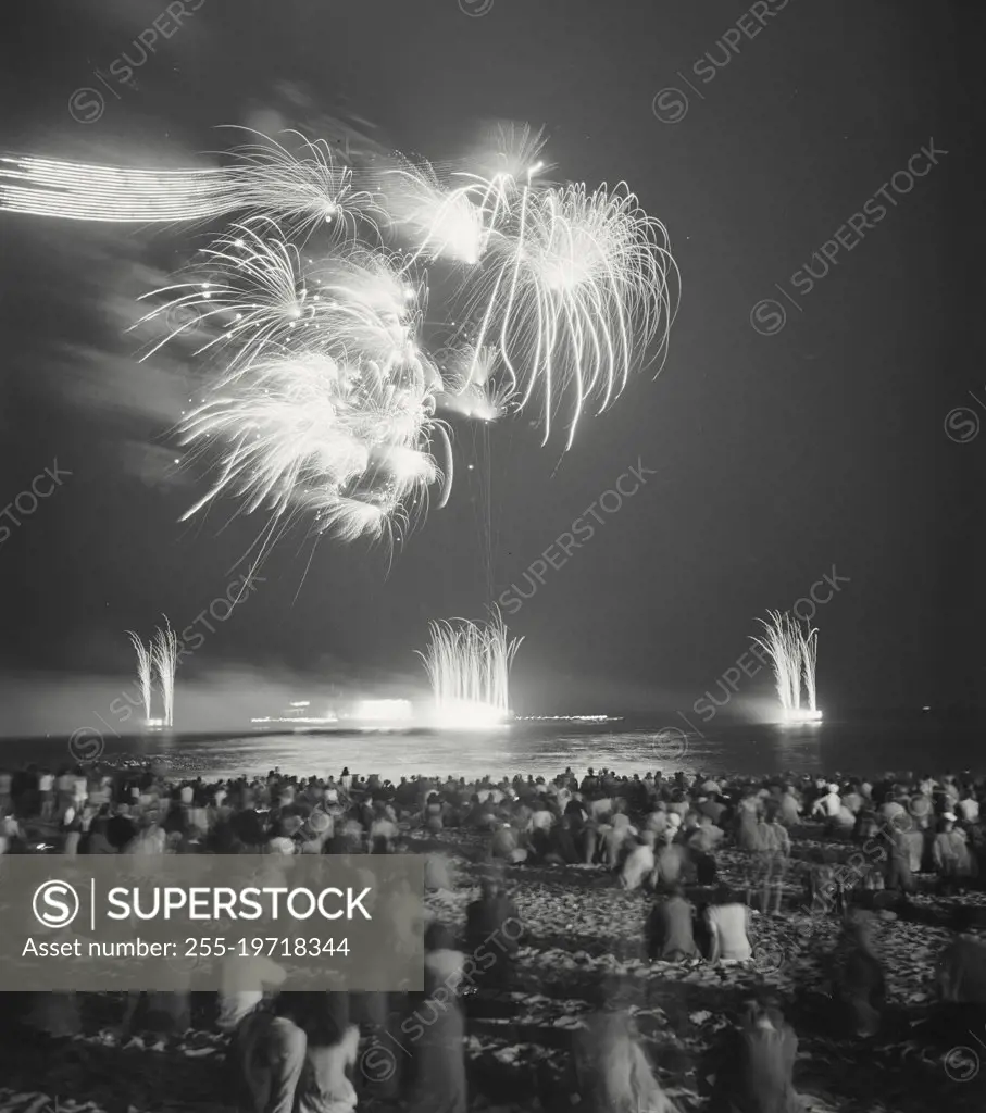 Vintage photograph. Crowd watching fireworks at the beach