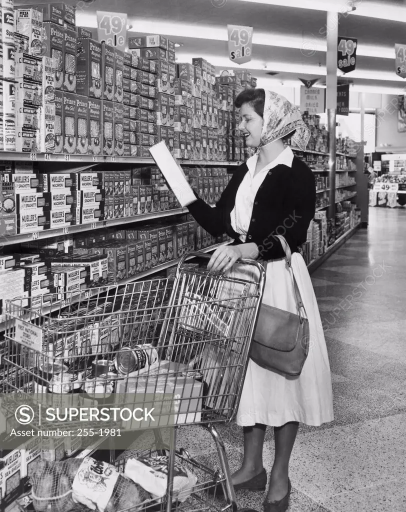 Side profile of young woman reading box in a grocery store