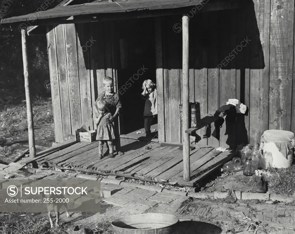 Vintage Photograph. High angle view of three children standing on the porch, Kentucky, USA