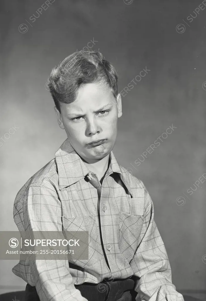 Vintage photograph. Boy wearing button up shirt making comical expression
