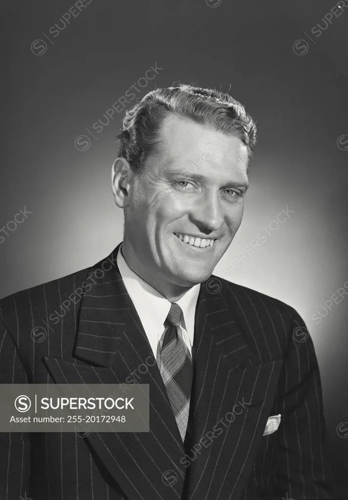 Vintage photograph. Handsome blonde man in pinstripe suit smiling