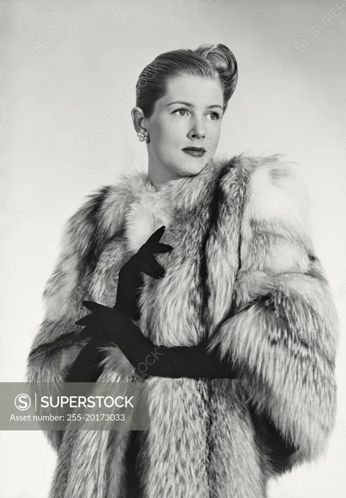 Vintage photograph. Woman in luxurious fur coat looking away