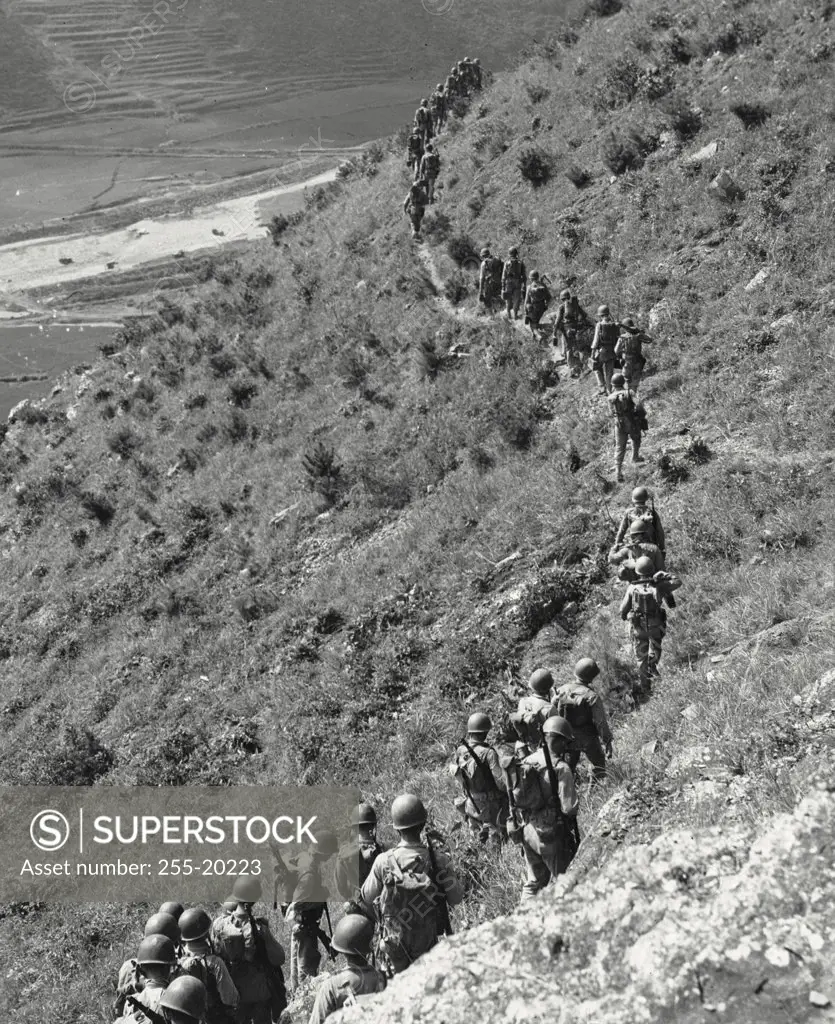 Vintage photograph. Marines move out of a rugged mountain train while closing with a hostile North Korean forces