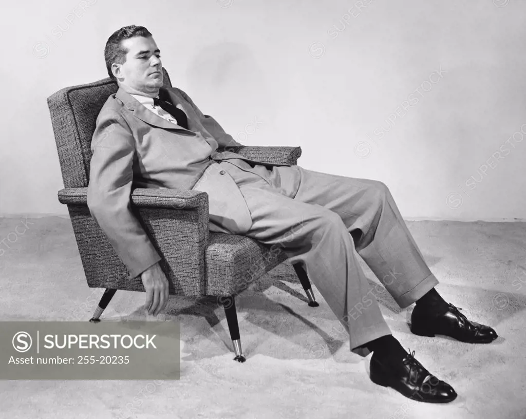 Side profile of a businessman reclining in an armchair