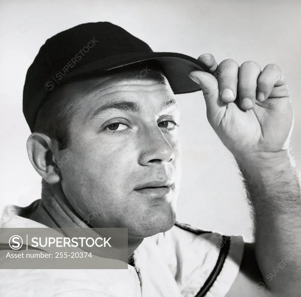 Portrait of a young man adjusting his cap