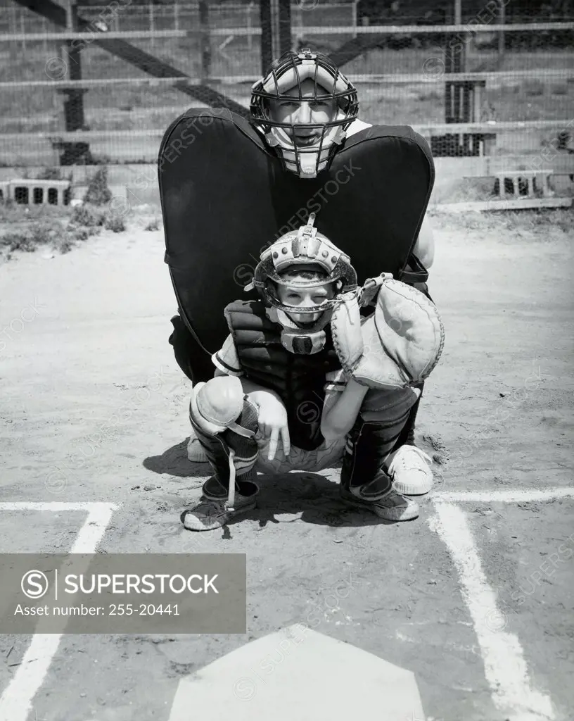 Baseball catcher crouching in front of a baseball umpire