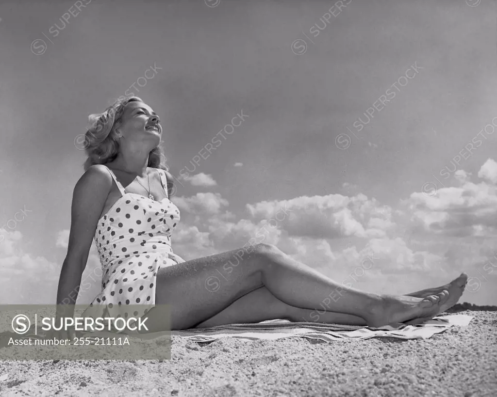 Low angle view of a young woman sunbathing on the beach