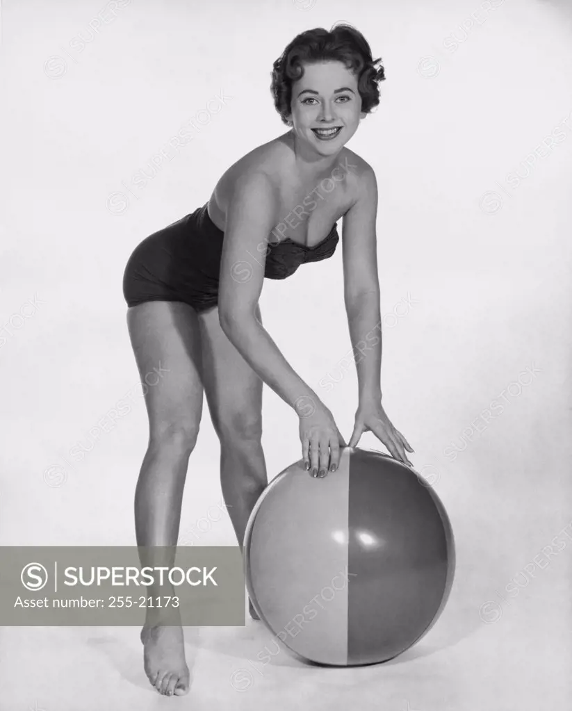 Portrait of a young woman posing with a beach ball