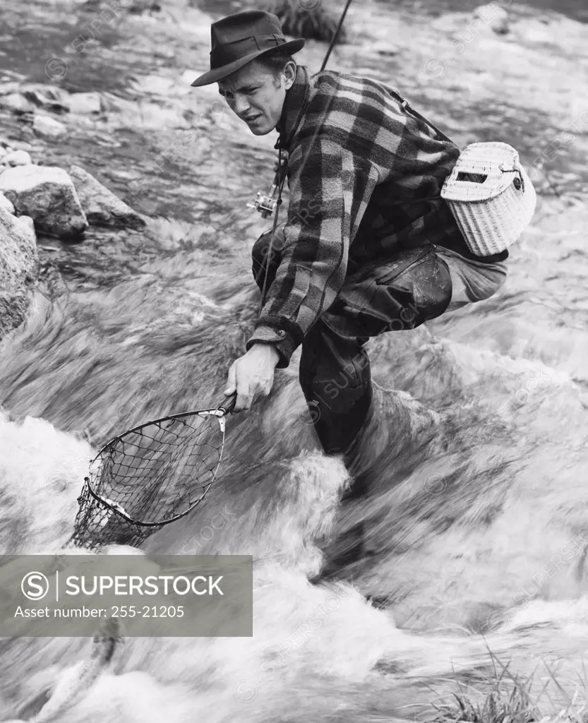 Side profile of a mid adult man fishing in a river