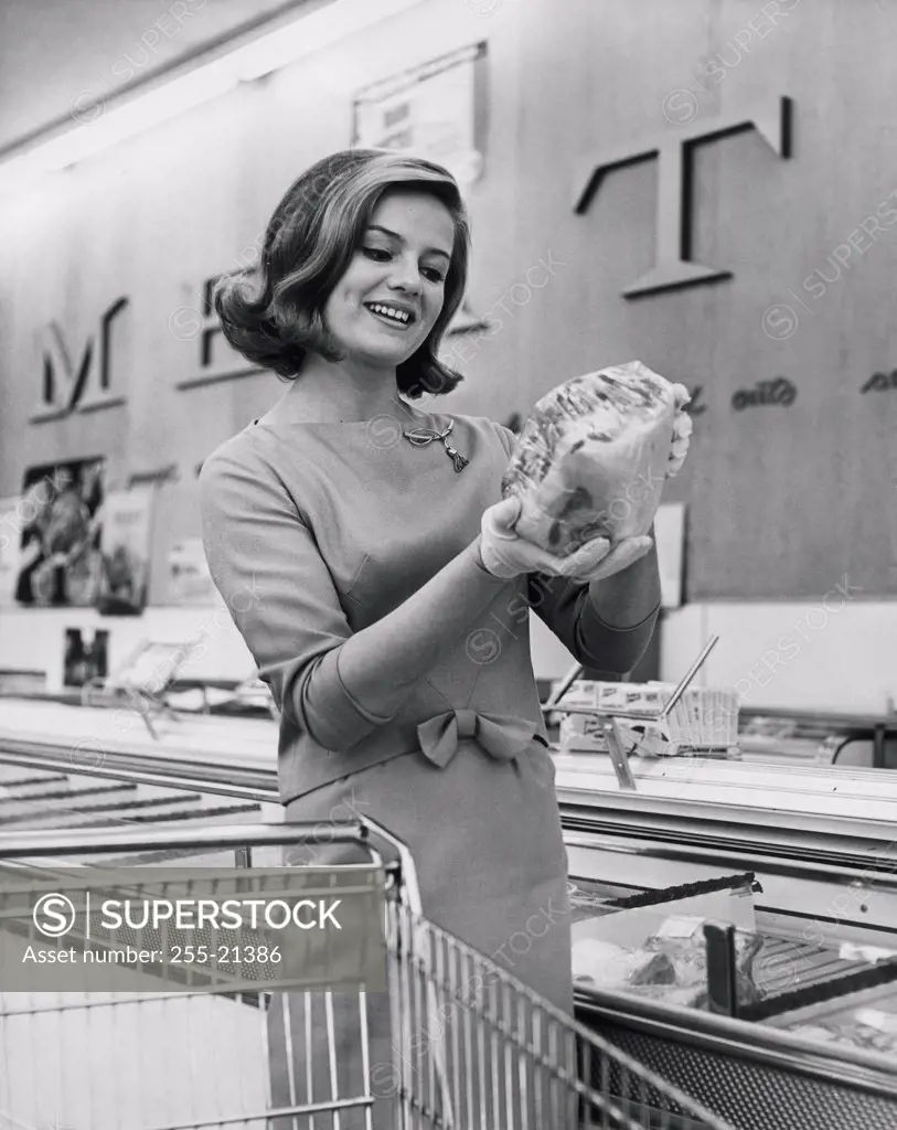 Young woman holding pre-packaged food in a grocery store