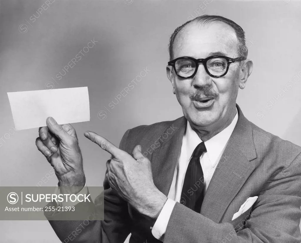 Portrait of a businessman pointing at a piece of blank paper
