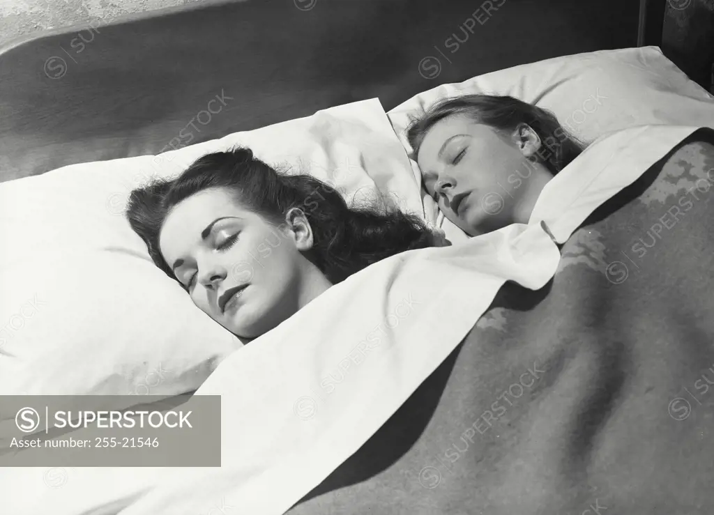 Vintage Photograph. Two women sleeping next to each other in bed with covers pulled up