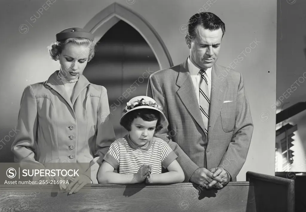 Vintage Photograph. Family standing in church with heads bowed