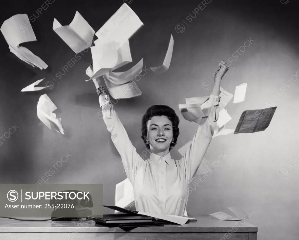 Portrait of businesswoman throwing papers