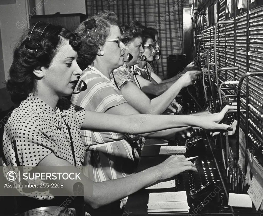 Vintage photograph. Nine girls handle the volume of telephone calls that keep switchboard busy