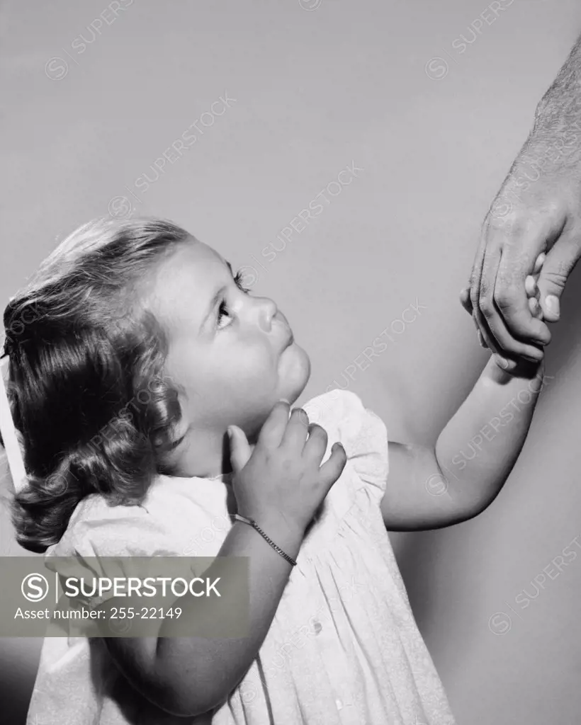 Close-up of a girl holding her father's hand