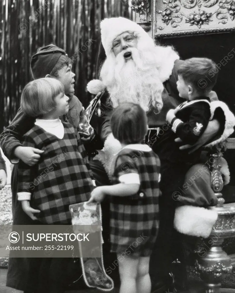 Portrait of Santa Claus talking with four children