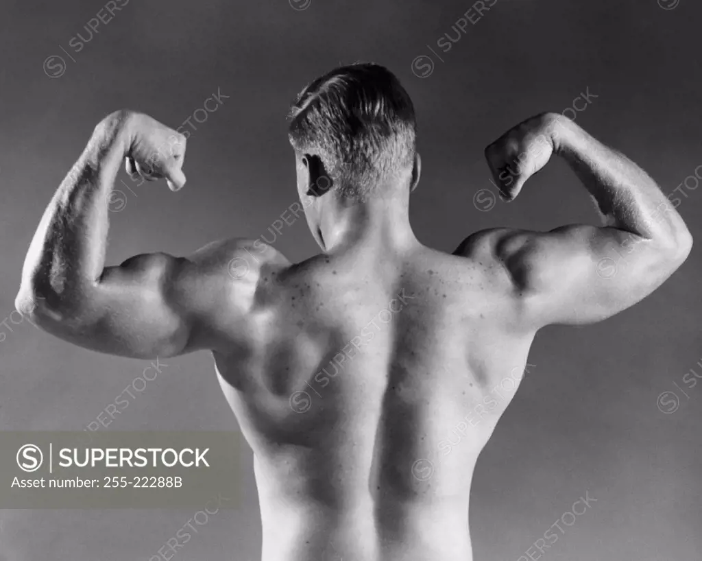 Rear view of a male body builder flexing his muscles