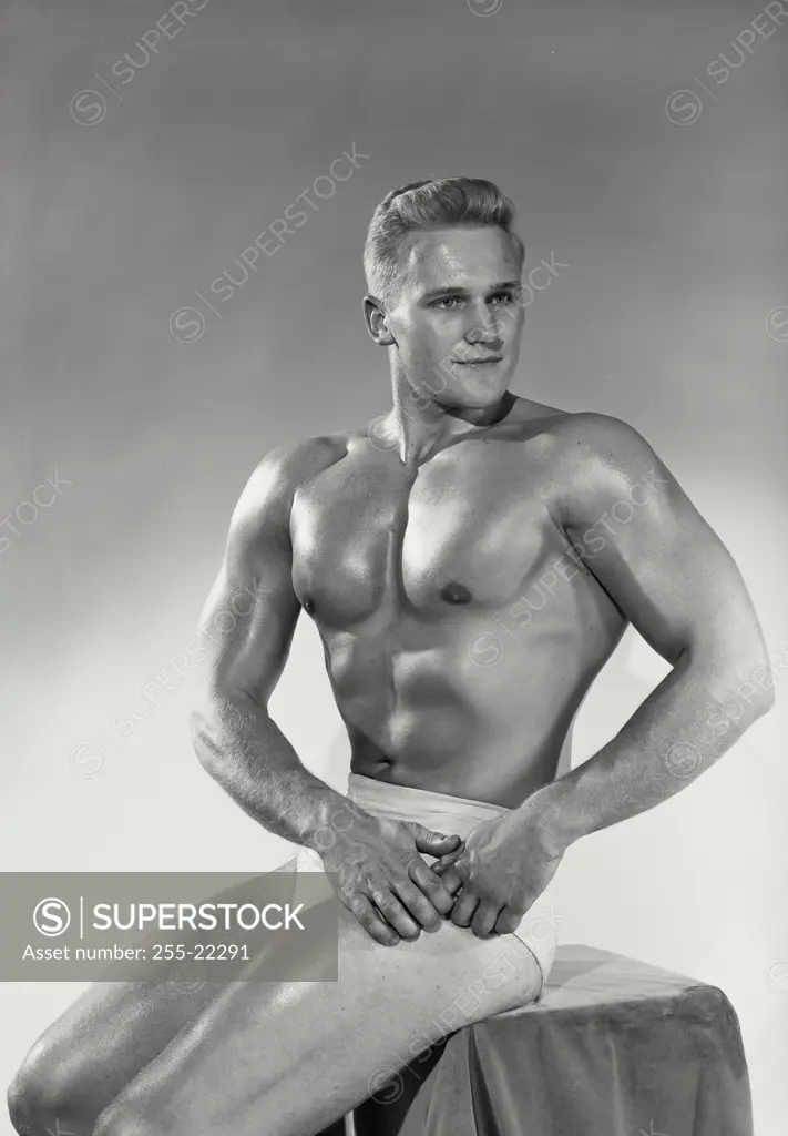 Vintage Photograph. Male bodybuilder sitting down striking pose, Frame 2