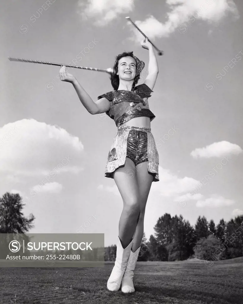 Low angle view of a drum majorette performing with two batons