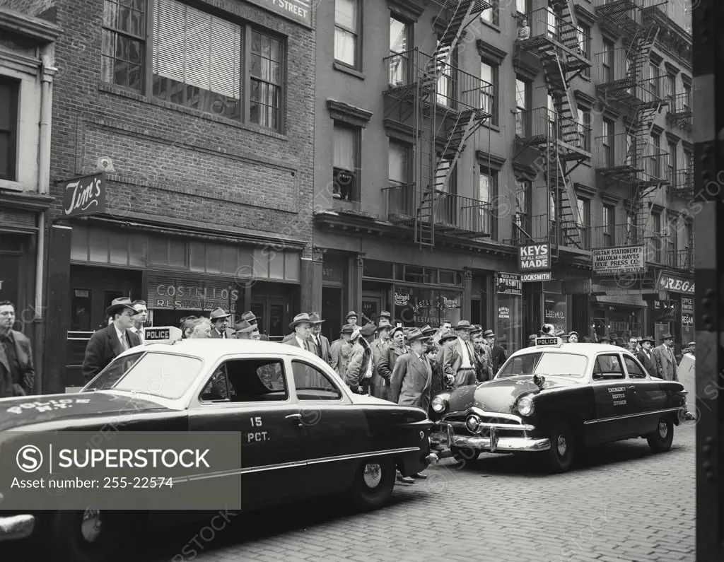 Vintage photograph. Crowd gathered around police cars watching the aftermath of a bus and taxi accident on 3rd Avenue, New York City