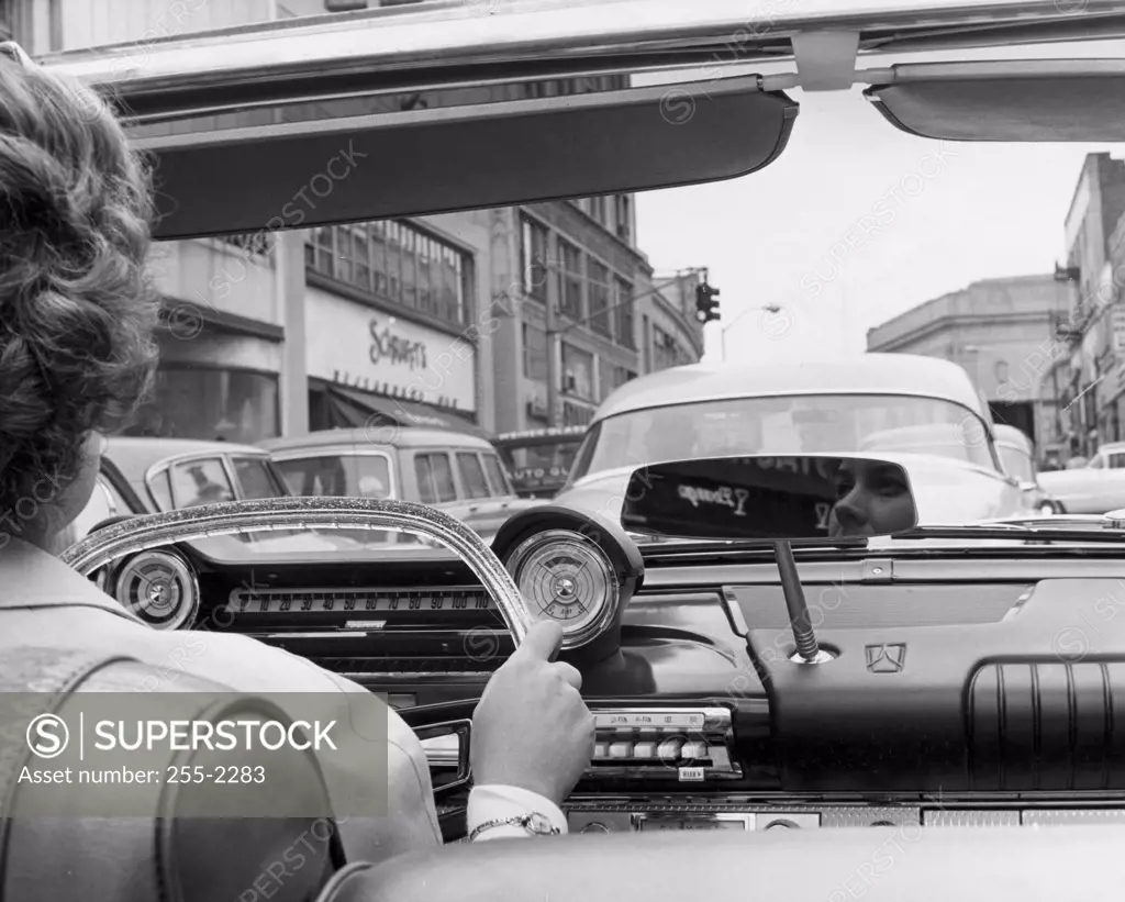 Rear view of a woman driving a convertible car