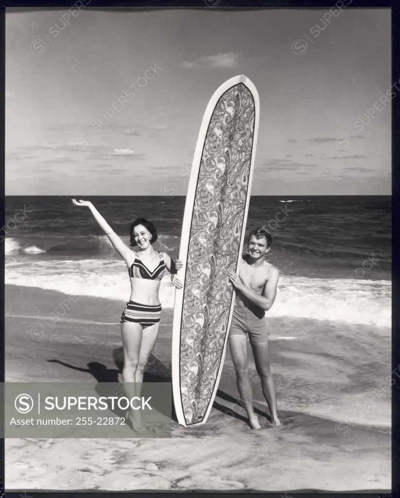 Young couple holding surfboard on beach