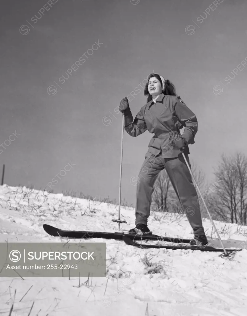 Low angle view of a young woman skiing on snow