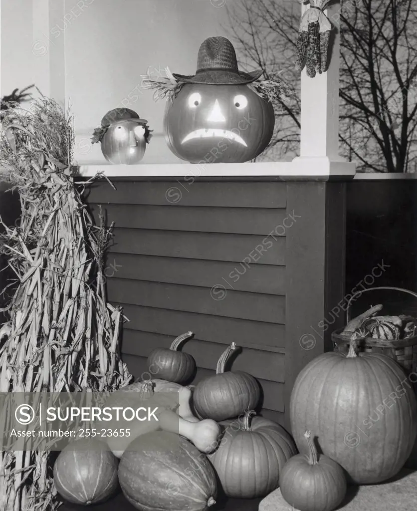 Illuminated jack o' lantern with pumpkins on a porch