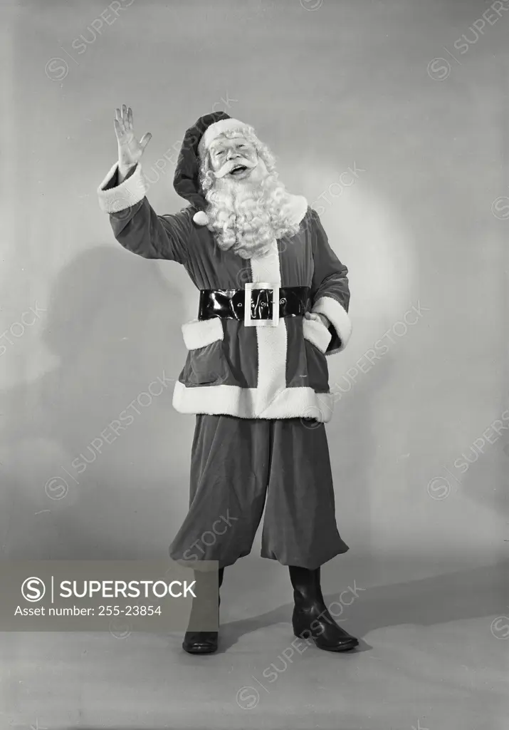 Vintage photograph. Close-up of man in Santa Claus costume smiling with hand raised