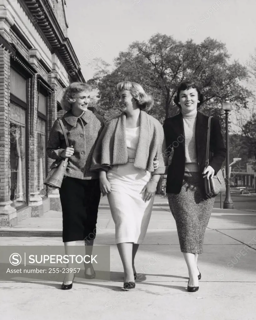 Three young women walking on the sidewalk