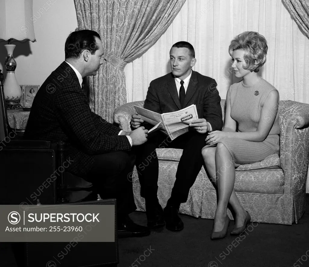 Young couple talking to insurance agent