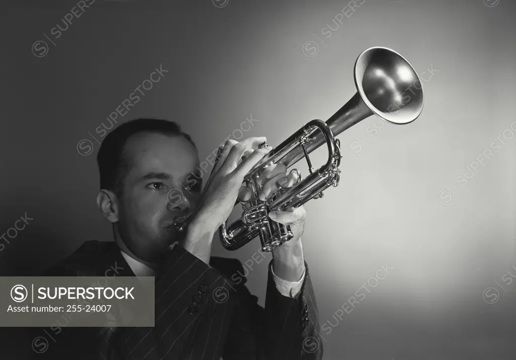 Vintage photograph. Close-up of a young man playing a trumpet
