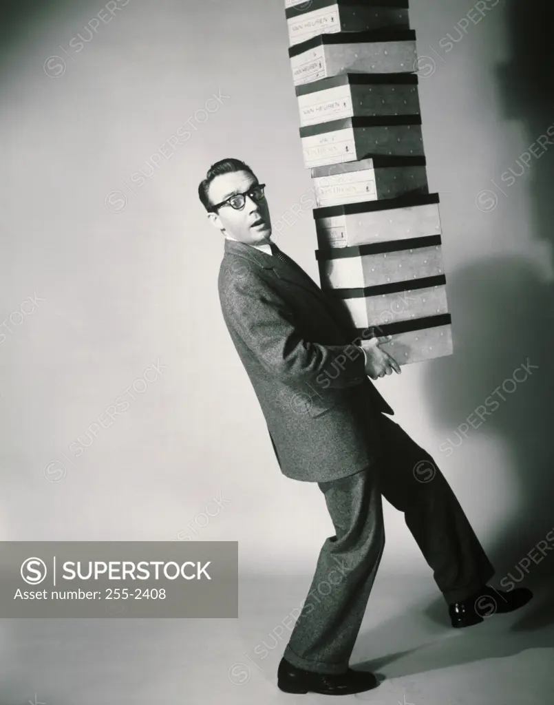 Side profile of a salesman carrying a stack of shoeboxes