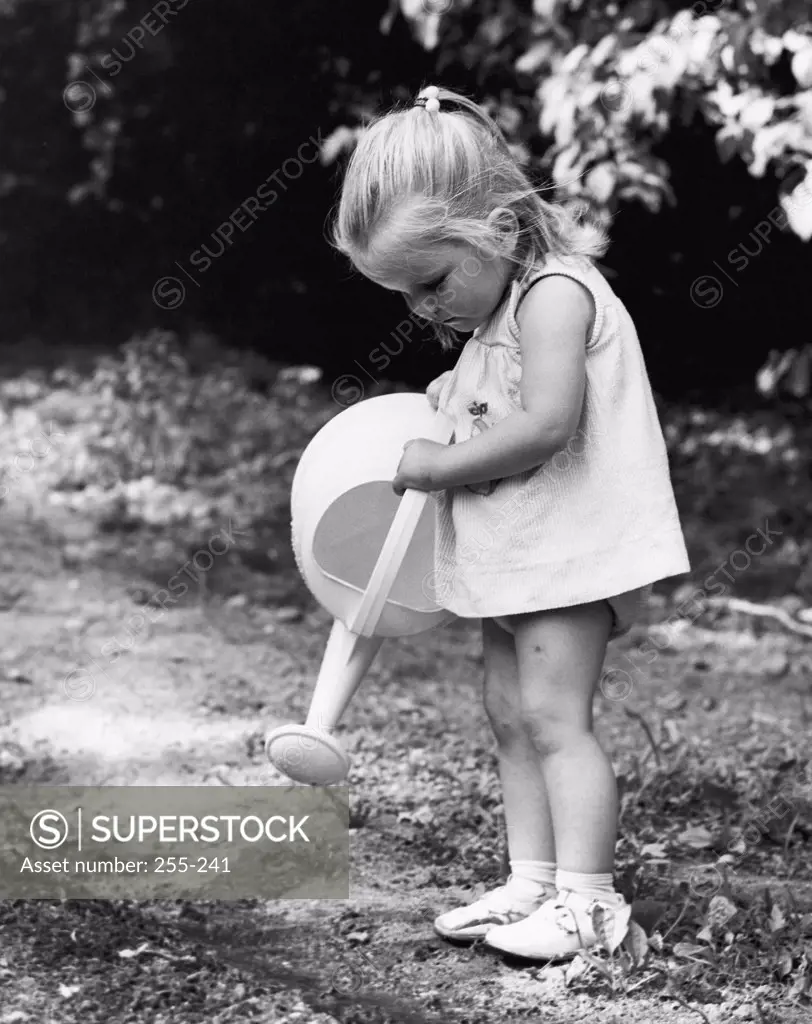 Side profile of a girl holding a watering can