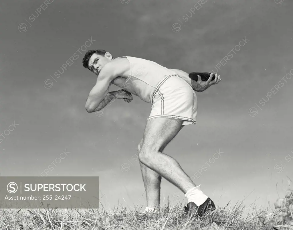 Vintage photograph. Athlete winding up to throw discus.