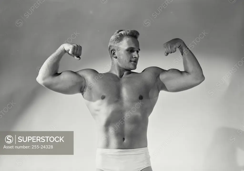 Vintage Photograph. Male bodybuilder striking pose in front of paper background, Frame 8