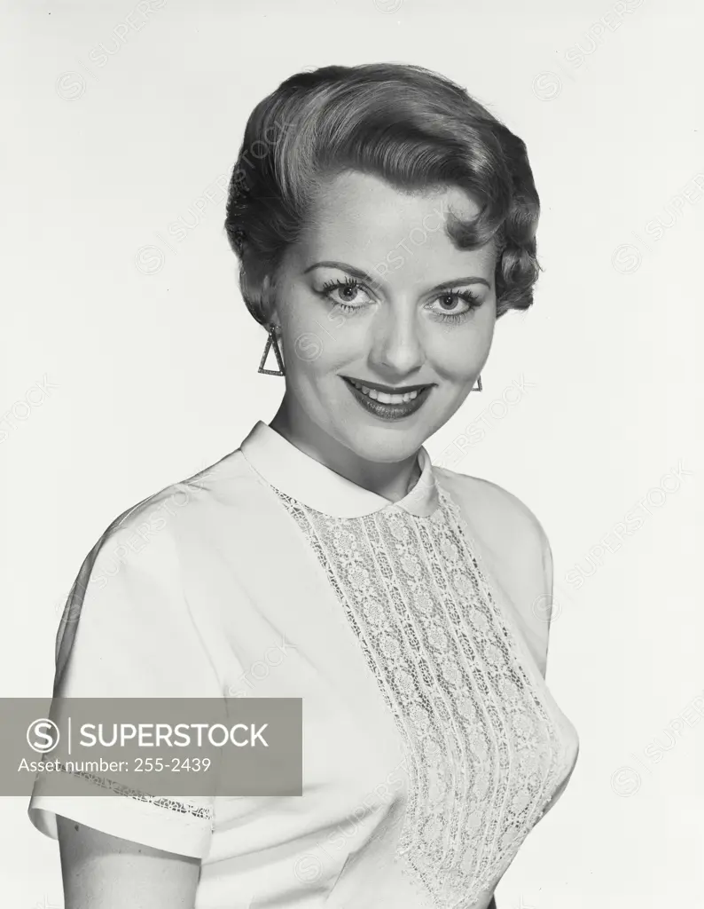 Vintage Photograph. Young woman with short hairstyle smiling at camera wearing blouse with floral detail in center, Frame 3